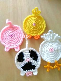 three crocheted birds sitting on top of a wooden table