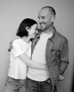 black and white photograph of a man and woman hugging each other in front of a wall