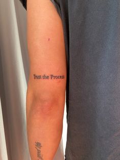 a man with a tattoo on his arm that reads trust the process and has writing underneath it