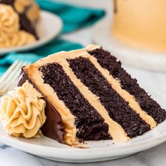 a slice of chocolate cake on a plate with a fork and cupcakes in the background