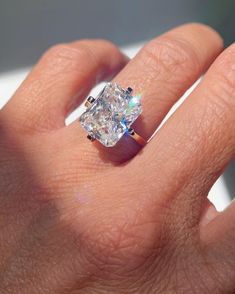 a woman's hand with a diamond ring on it