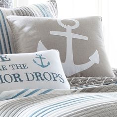 a bed with two pillows and an anchor pillow