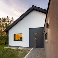 a white house with a black roof and windows