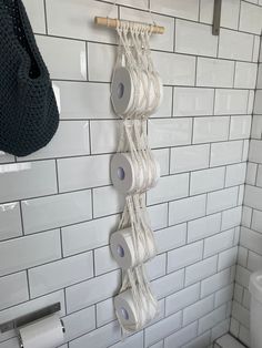 several rolls of toilet paper are hanging on the wall in this white tiled bathroom area