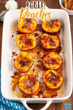 baked peaches in a casserole dish on a wooden table with the words baked peaches above them