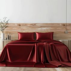 a bed covered in red sheets and pillows