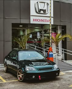 a black car parked in front of a honda dealership