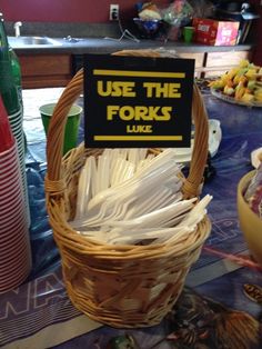 a basket with forks in it sitting on top of a table next to soda bottles