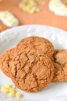 three cookies on a white plate with yellow candies in the foreground and another cookie in the background