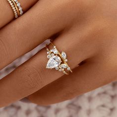 a woman's hand with three different rings on her fingers and one has a diamond ring