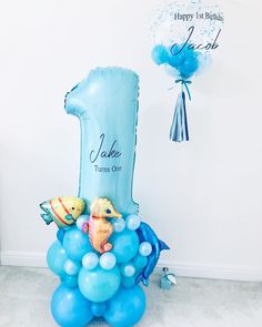 a balloon shaped like the number one with sea animals on it and balloons floating in the air