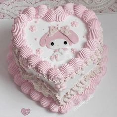 a heart shaped cake decorated with pink and white icing