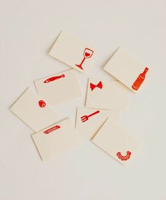 six red and white coasters with different types of utensils on each one