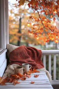 a coffee cup on a bench with autumn leaves