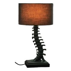 a lamp that is sitting on top of a table with a brown shade over it