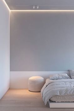 a white bed sitting under a ceiling light in a bedroom next to a wooden floor