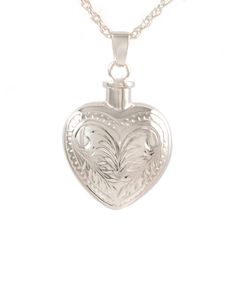 a silver heart shaped locke necklace on a chain with an engraving design in the center