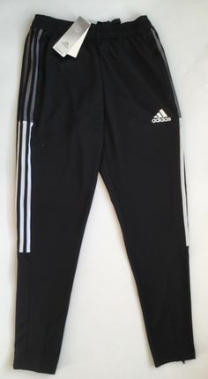 TIRO 21 TRACK PANTS TAPERED TRACK PANTS MADE WITH RECYCLED MATERIALS. Too good to limit to the pitch. The adidas Tiro pants debuted as training wear, but they're now a streetwear staple. Ankle zips allow you to pull these pants on over sneakers. Moisture-absorbing AEROREADY ensures you stay dry no matter where life takes you. SPECIFICATIONS Regular tapered fit Drawcord on elastic waist 100% recycled polyester doubleknit Moisture-absorbing Front zip pockets Ribbed lower legs with ankle zips Aeror Functional Black Adidas Pants, Adidas Trackpant, Adidas Tiro Pants, Boys Track Pants, Men’s Track Pants, Black Track Pants, Lululemon Men, Adidas Track Pants, The Pitch