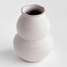 two white vases stacked on top of each other