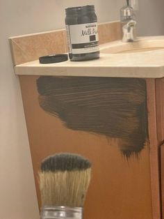 a paintbrush sitting on top of a wooden cabinet