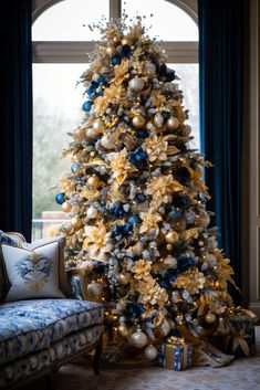 a blue and gold christmas tree in a living room