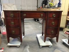 an antique desk is being worked on in a garage