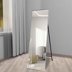 a mirror sitting on top of a wooden floor next to a window