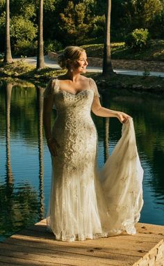 a woman in a wedding dress standing on a dock