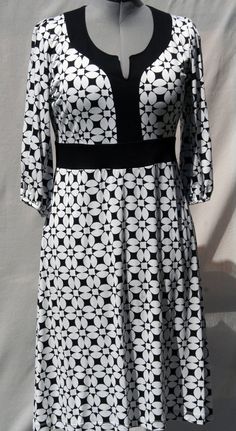 The "Nico" dress is made of light cotton jersey fabric. The fabric has black and white graphic flowers pattern printed. The are black contrast yokes on the neckline and around the waist. The dress has 2 bust darts. The 3/4 sleeves are gathered. The dress has a tapezoid shape from the waist to the knees. Dress length: 108 cm Size: Fr L (42) Composition: 50% Cotton - 46% Polyfiber - 4% Elasthanne Care of clothing: Wash 30oC - Cool iron - Dry cleaning Cotton V-neck Dress With Graphic Print, White Stretch A-line Maxi Dress, White Stretch Cotton Midi Dress, Elegant Black Dress With Graphic Print, Cotton Graphic Print Patterned Dresses, Patterned Cotton Dress With Graphic Print, Printed Black A-line Midi Dress, Printed A-line Black Midi Dress, White Floral Print Stretch Maxi Dress