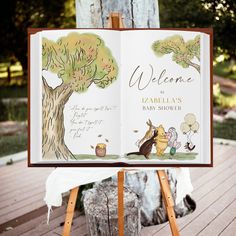 an open children's book sitting on top of a easel next to a tree