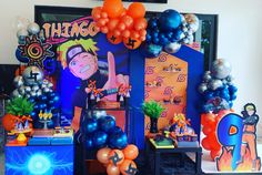 an assortment of balloons and decorations on display in a room with blue walls, black flooring and orange accents