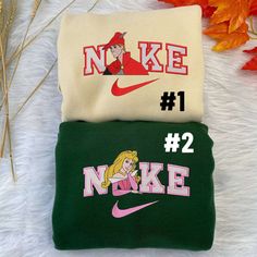 Introducing the enchanting Princess Aurora and Prince Phillip Disney Nike Embroidered Sweatshirts! Embrace the magic and relive your favorite fairy tale moments with these exquisite sweatshirts. Made with premium quality materials, they offer ultimate comfort and durability. The intricate embroidery showcases the beloved characters in stunning detail, adding a touch of elegance to your wardrobe. Whether you’re a devoted Disney fan or simply appreciate timeless love stories, these sweatshir Stitch And Angel Nike Hoodie, Cheap Fan Merchandise Sweatshirt With Character Print, Disney Inspired Sweatshirt, Hand Embroidered Sweatshirt Disney, Disney Hoodies Sweatshirts, Cheap Disney Crew Neck Sweatshirt, Personalised Disney Gifts, Disney Sweat Shirts, Prince Phillip Disney