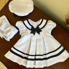 Nwot Rare Editions Dress Is A White And Navy Blue Color, With Matching Hat And Panties. Classic Cuteness In New Condition! See Close Up Picture For Colors And Details Fitted Sailor Dress With Short Sleeves, Sailor Style Short Sleeve Fitted Dress, White Sailor Dresses For Spring, White Sailor Style Dress For Spring, White Sailor Style Spring Dress, Navy Fitted Cute Dress, Cute Fitted Navy Dress, White Sailor Cotton Dress, Sailor Style White Cotton Dress