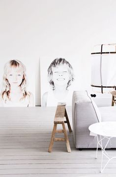 a living room with white walls and wooden flooring, two pictures on the wall