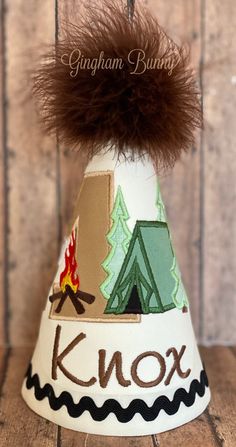 a paper hat with a campfire and tent on it that says knox