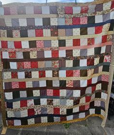 an old quilt hanging on the side of a building