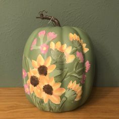 a painted pumpkin sitting on top of a wooden table