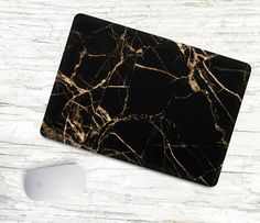 a black and gold marble mouse pad next to a computer mouse