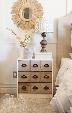 a dresser with drawers and a mirror on the wall above it next to a bed