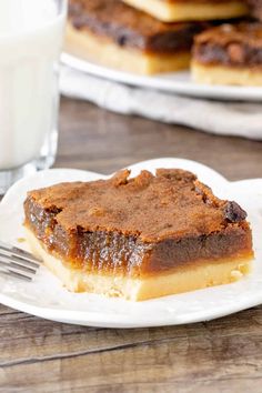 a piece of cake sitting on top of a white plate next to a glass of milk