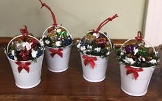 four white buckets filled with christmas decorations