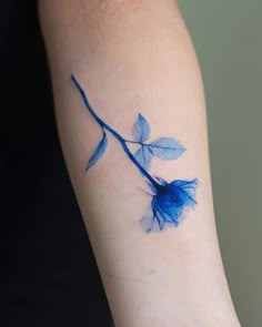 a blue rose tattoo on the left arm