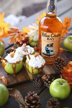 an apple cupcakes with whipped cream and caramel are sitting on a cutting board