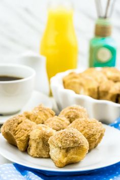 some food is sitting on a white plate next to two cups of coffee and an orange juice