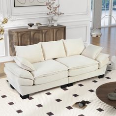 a living room with a white couch and coffee table on the floor in front of a large window