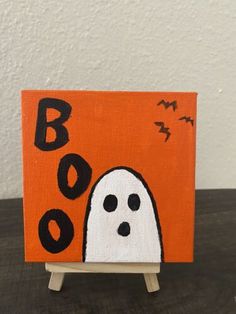 an orange and black halloween card with a ghost on it's face in front of the word boo