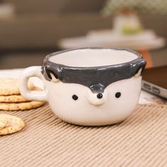 a cup with a face on it sitting next to crackers