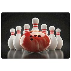 a bowling ball and some skittles on a reflective surface in front of a black background