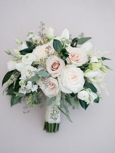 a bridal bouquet with white flowers and greenery