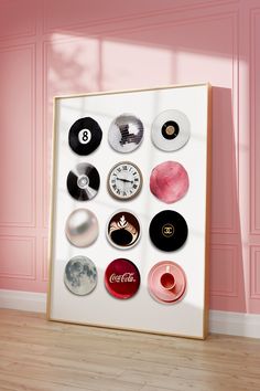 a white framed poster with various types of buttons on it in front of a pink wall